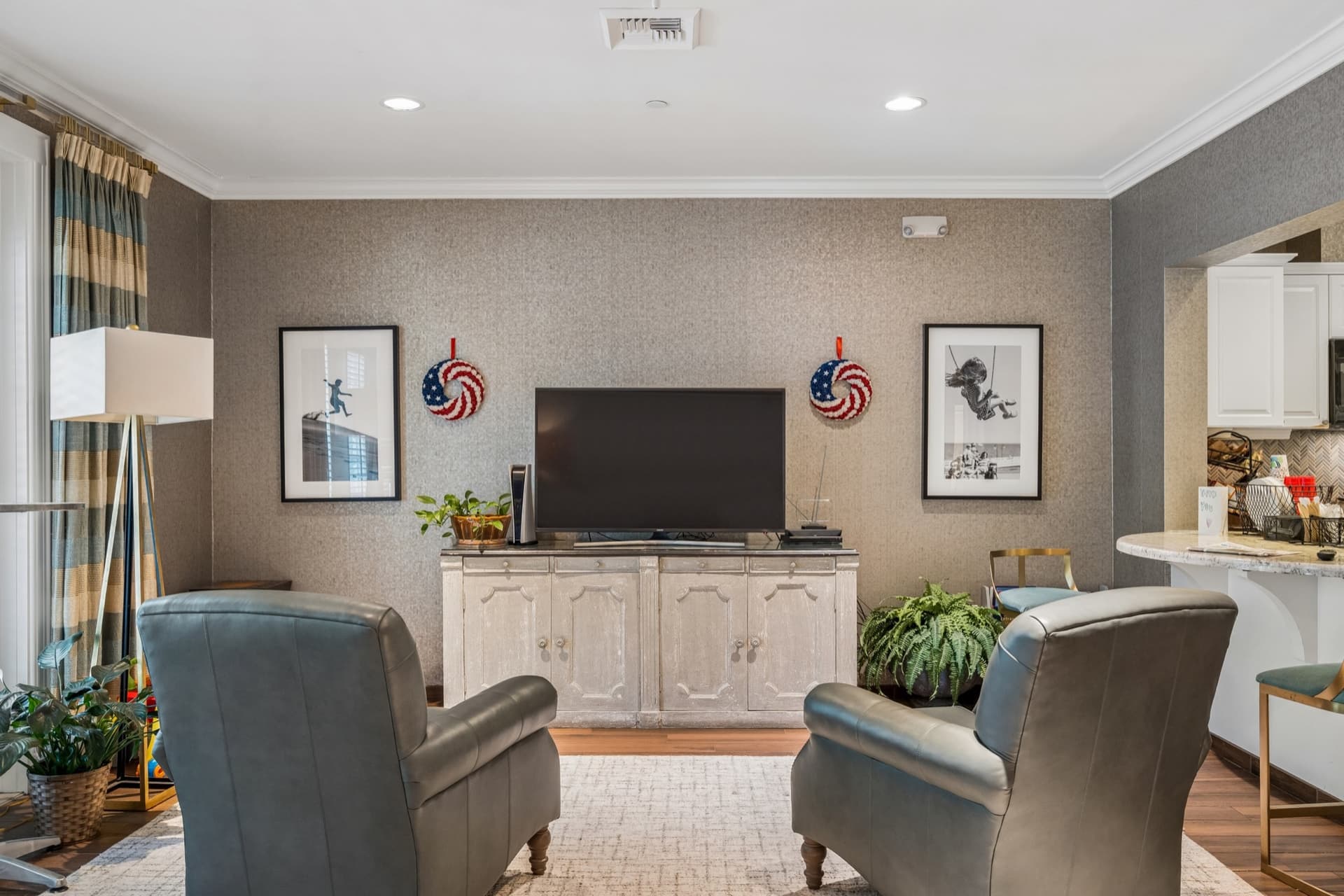 Living room with leather recliners, a large wall-mounted television, and patriotic artwork.