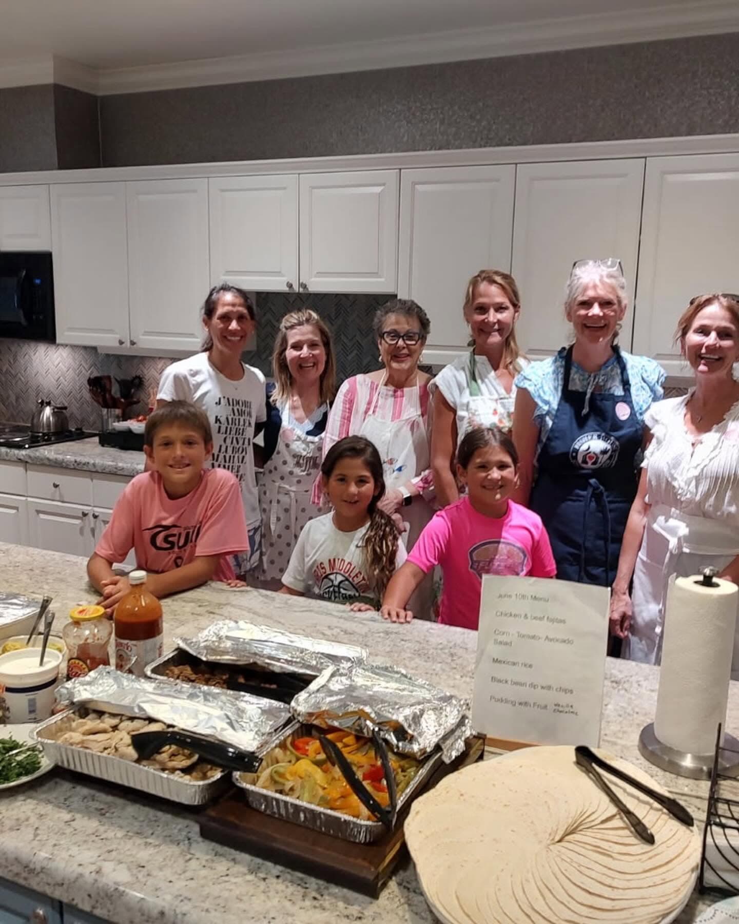 Harleston Village Association Heart & Hands Committee volunteers and young helpers gathered in the Fisher House kitchen behind trays of fajita fixings and tortillas