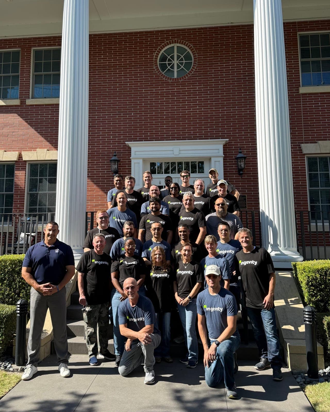 Twenty-seven Ingevity volunteers posing on the front steps of the Charleston Fisher House in matching branded t-shirts