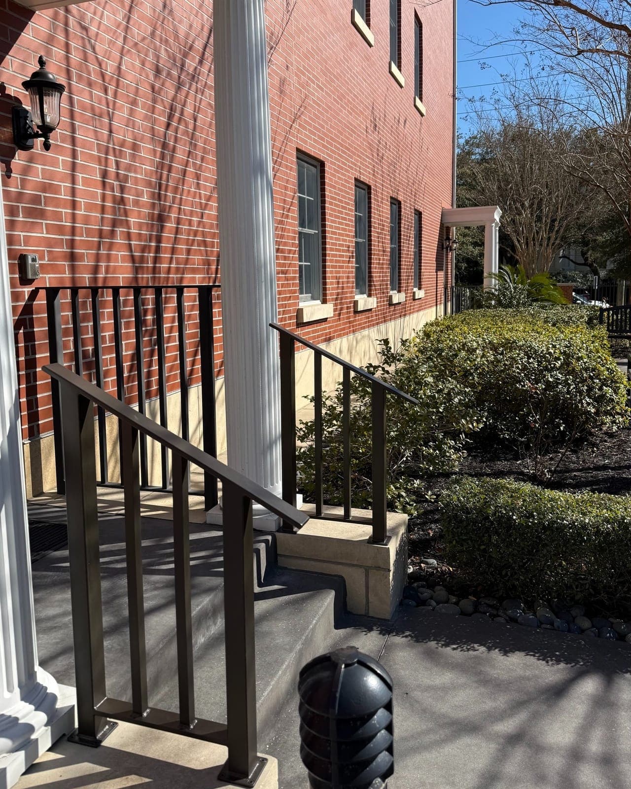 New dark metal ADA handrail installed on the exterior entrance steps of the Charleston Fisher House