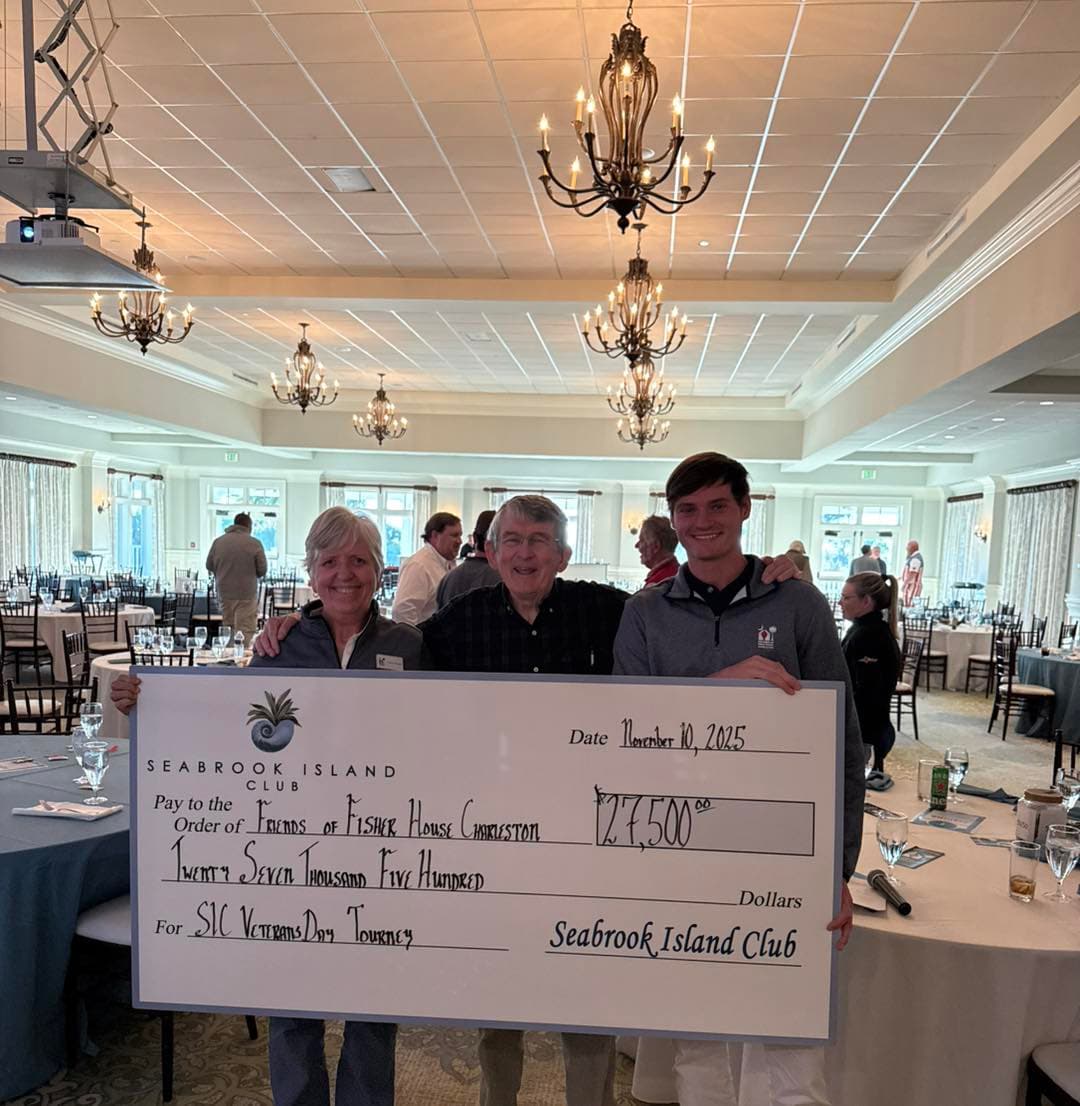 Three people holding a $27,500 Seabrook Island Club check made out to Friends of Fisher House Charleston in the club ballroom