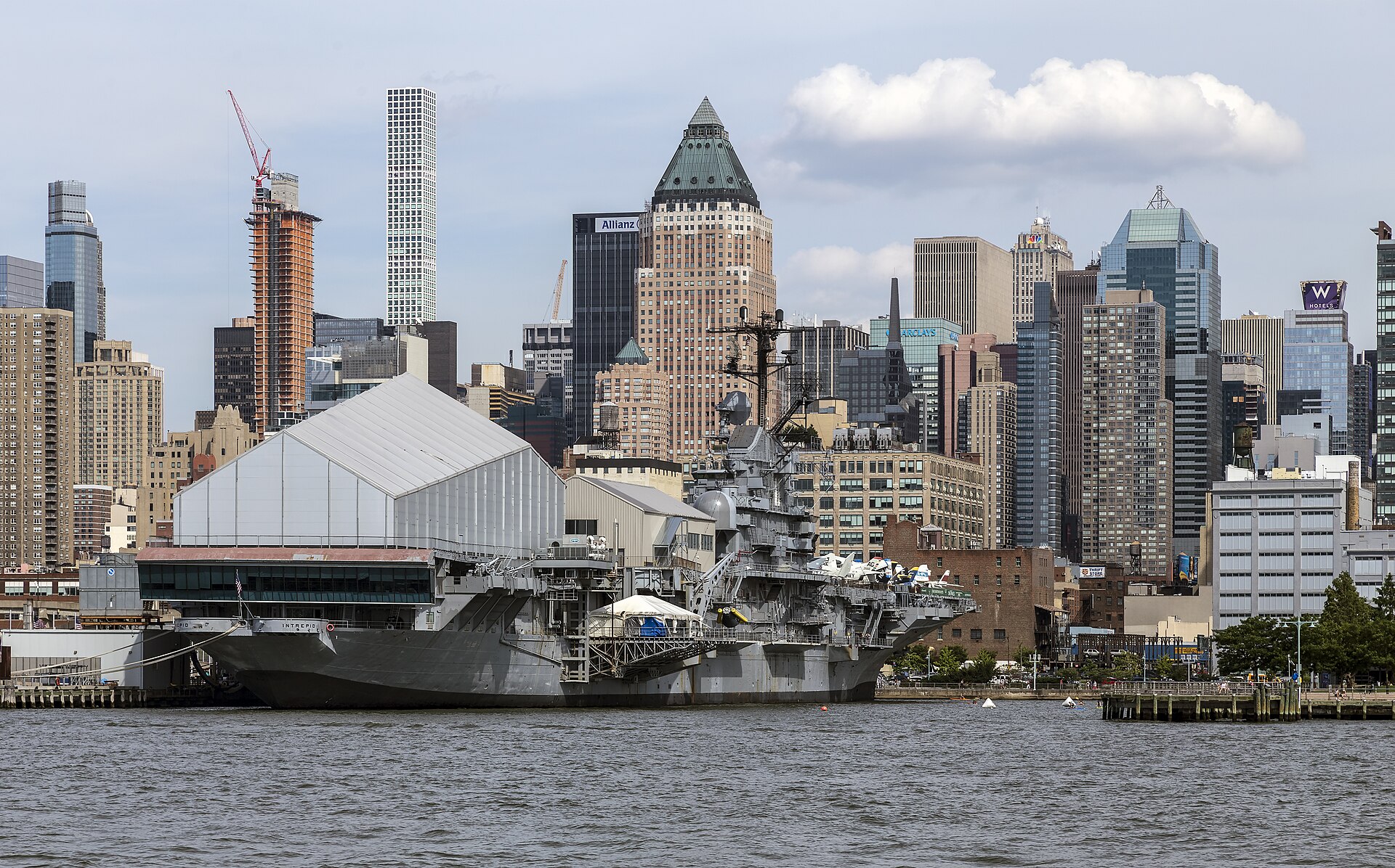 The Intrepid docked at Pier 86 as the Intrepid Sea, Air and Space Museum, aircraft on her deck and the Manhattan skyline rising behind her